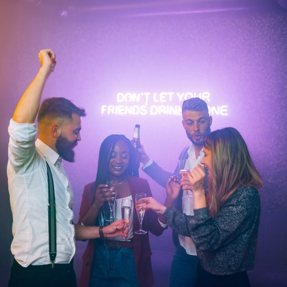 Friends dancing on a party in a club while drinking champagne